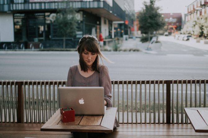 woman sitting outside with open laptop, apply for jobs