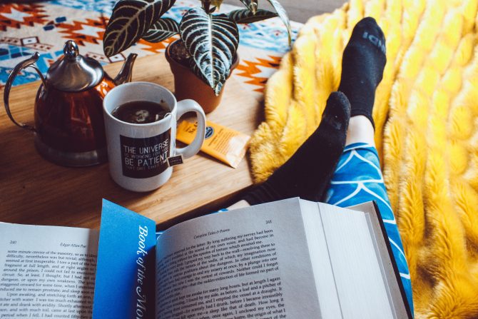 reading with a tea on a yellow blanket