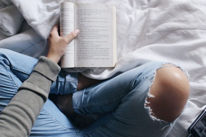 person sitting with an open book, reading