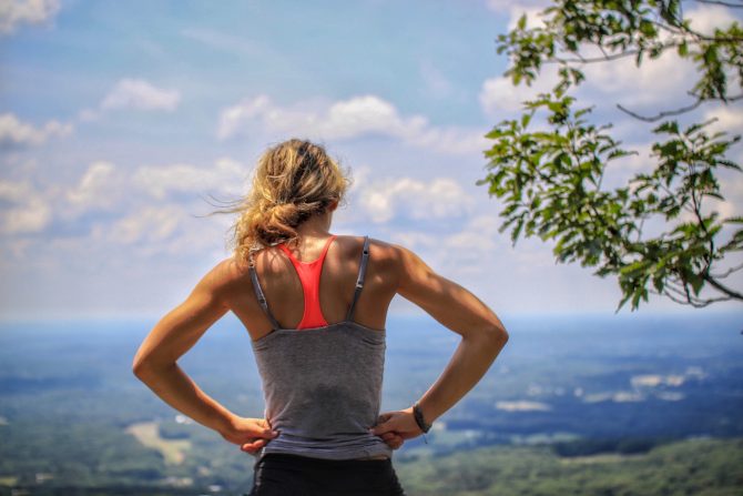 woman standing near tree looking below