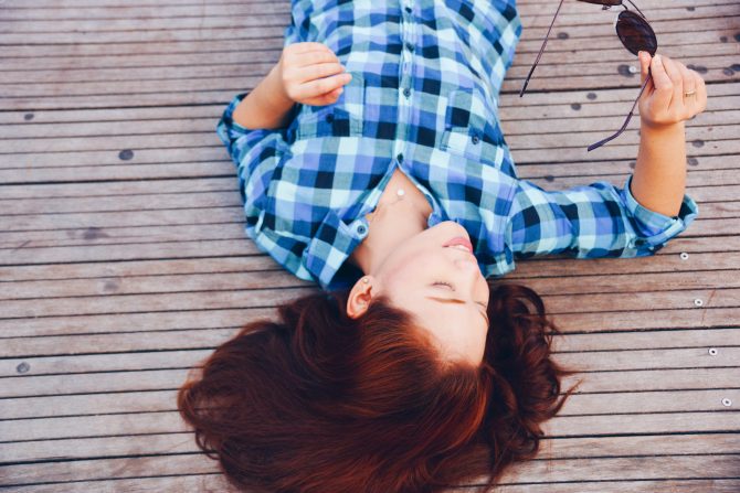 woman lying down with blue flannel shirt