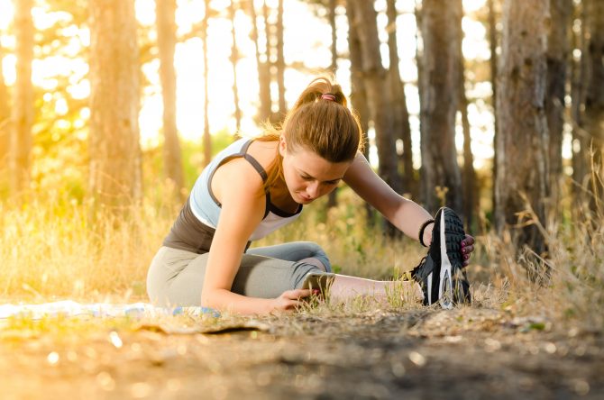 woman doing stretching near trees