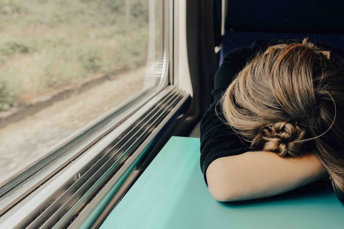 brain fog, tired woman sleeping on train