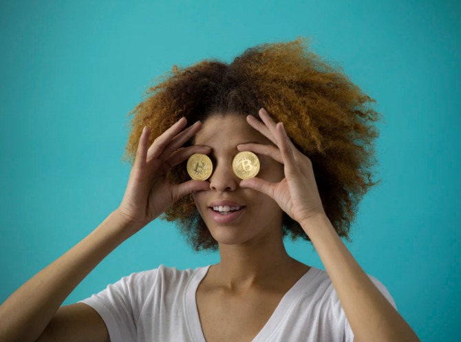 woman holding coins to her eyes