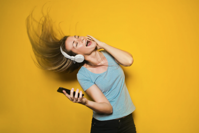 yellow background, woman singing along to music